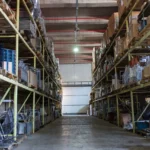 spacious warehouse filled with industrial metal shelving units giving idea about How to Start a Self Storage Business